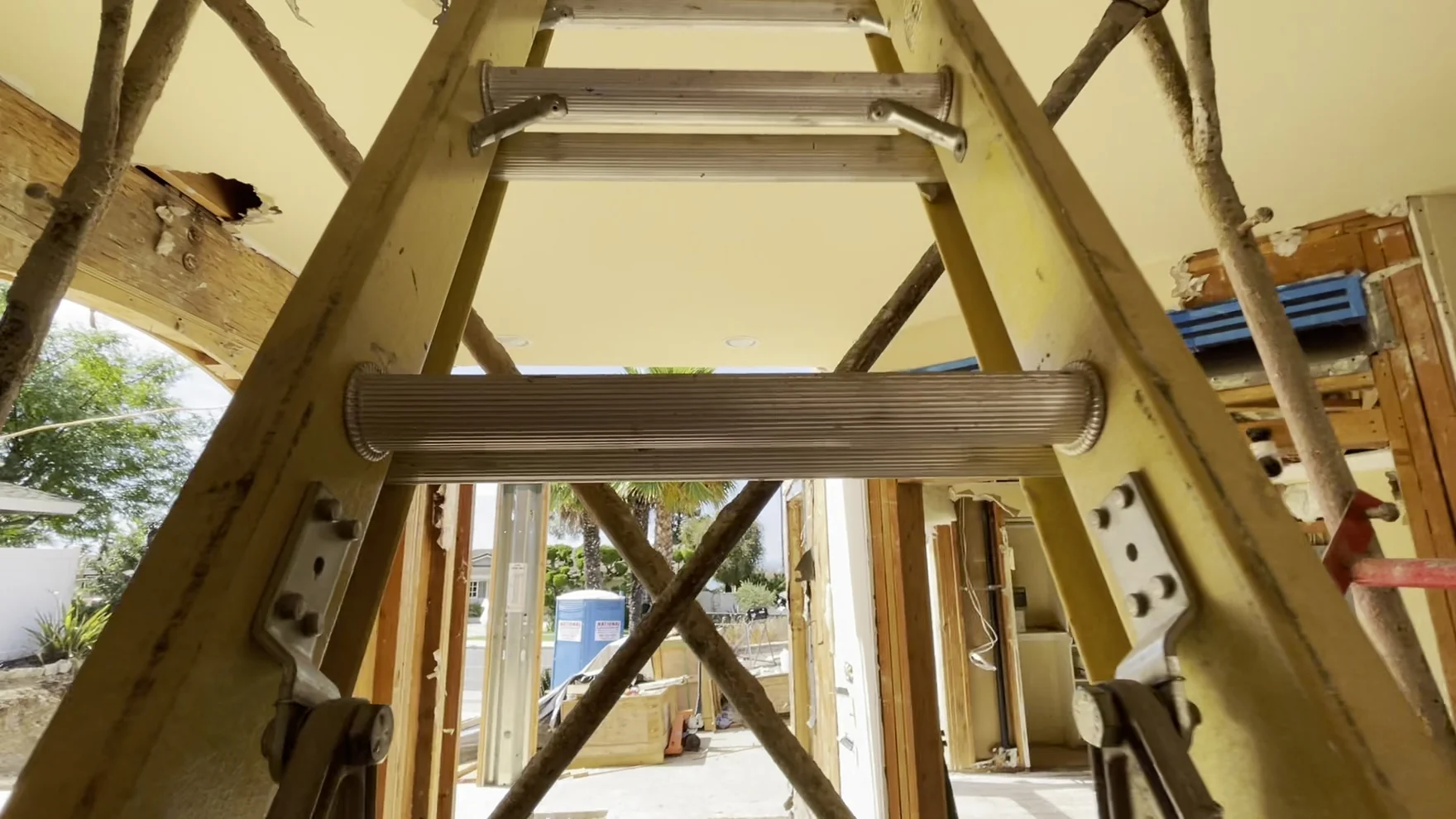 Laminated timber beams sitting on posts and joined with galvanized connectors, props still standing under the run