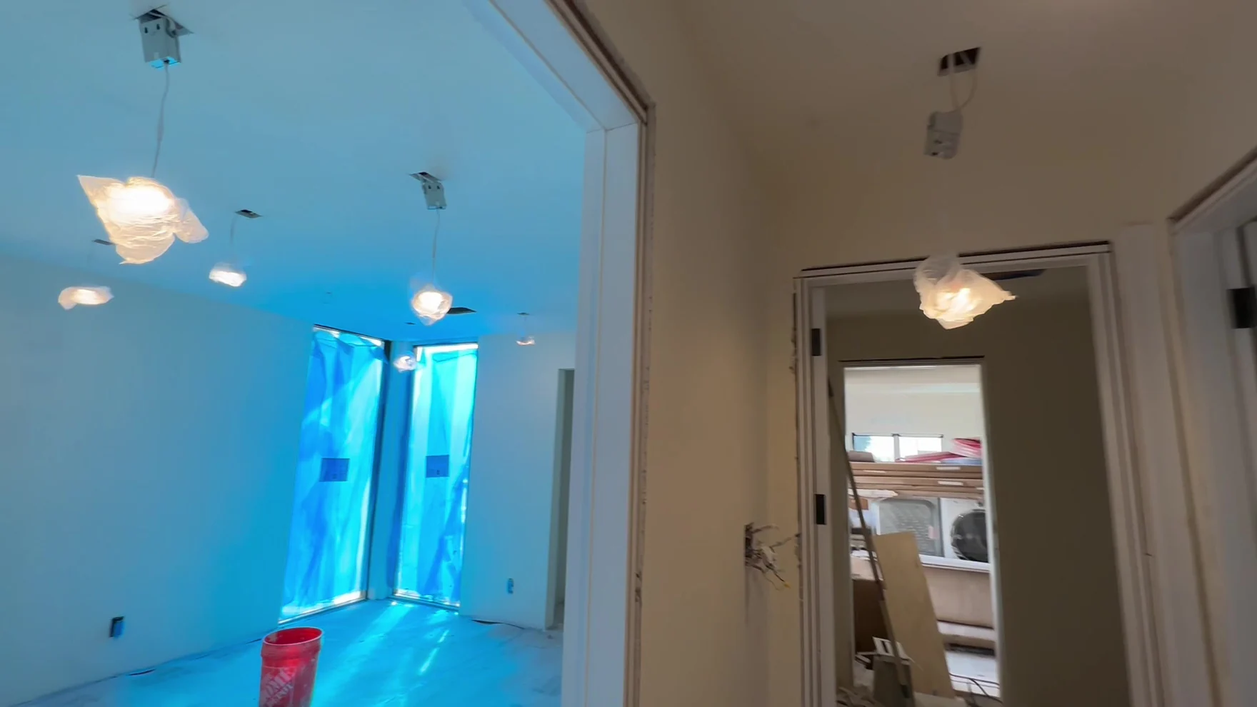 Room at drywall stage with taped board, framed openings and temporary work lighting