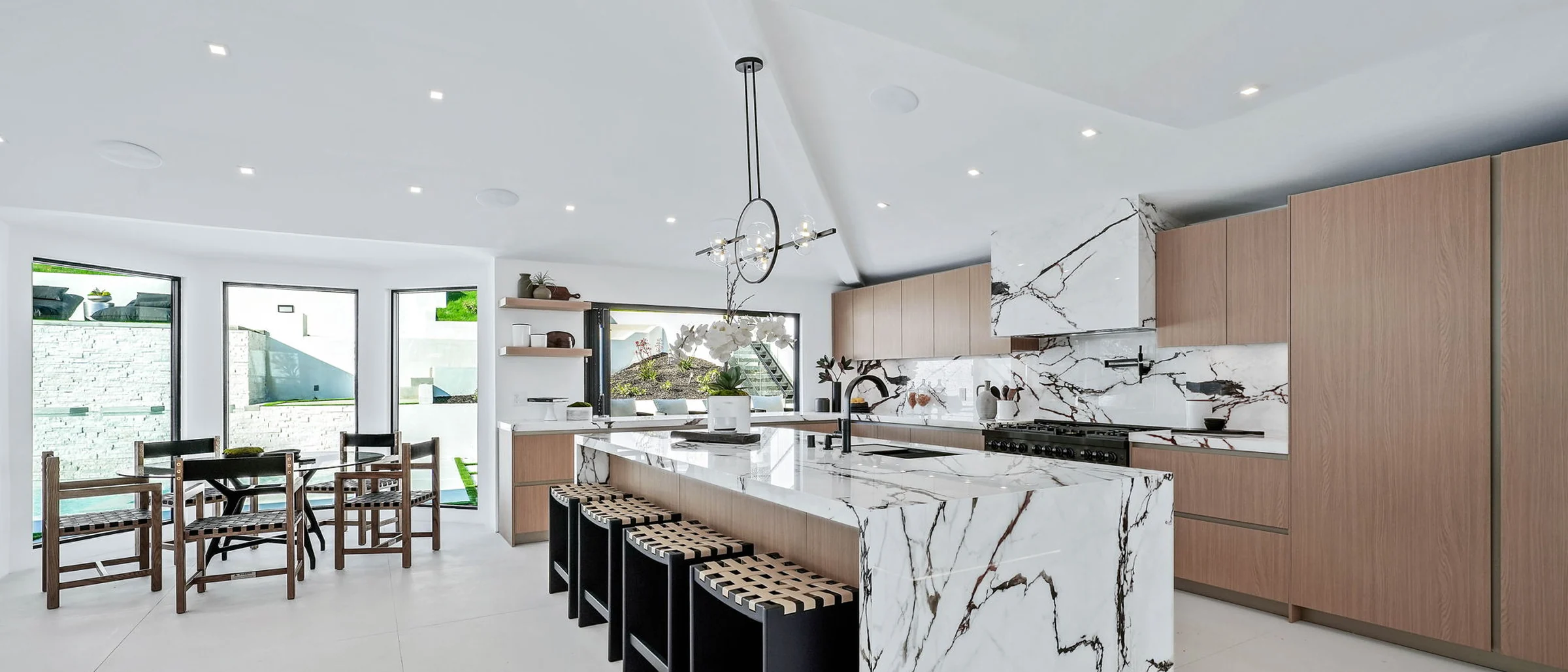 Wide view of the marble waterfall island and white oak kitchen in the finished house